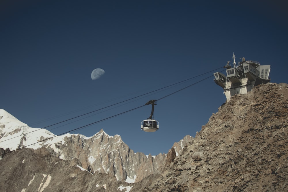 cable car over rocky mountain during daytime
