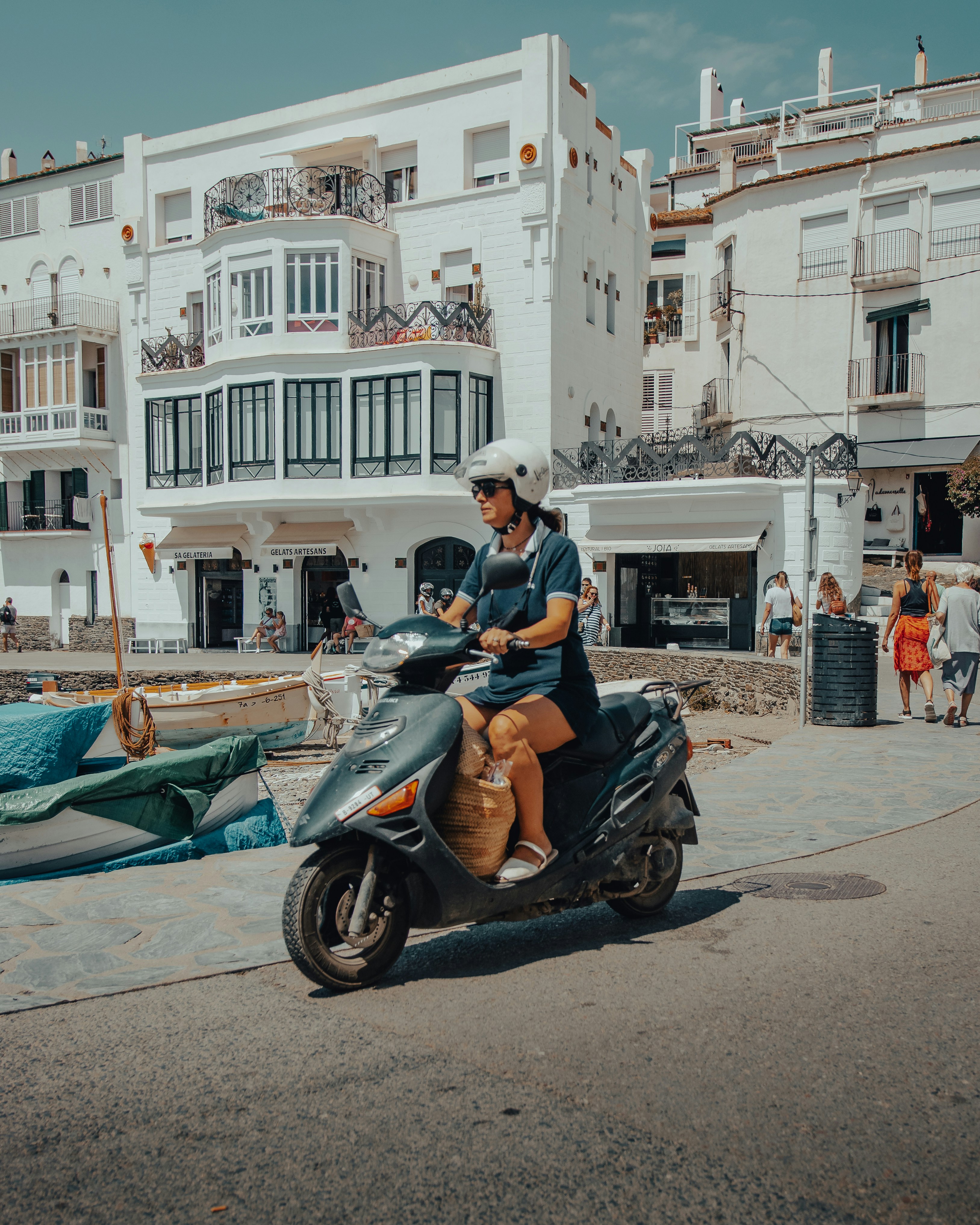 Mann in schwarzer Jacke fährt auf schwarzem Motorroller