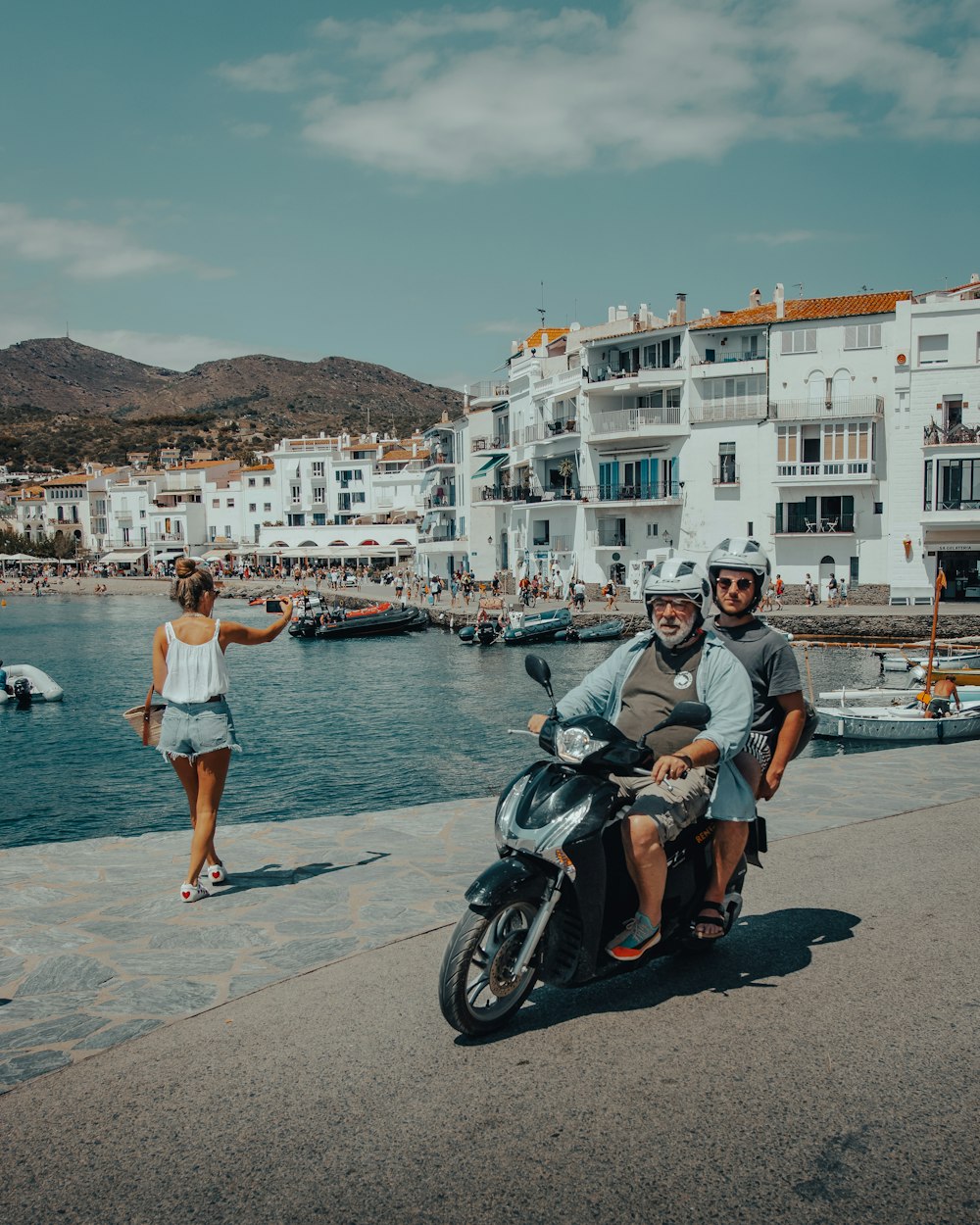  man and woman standing beside black motorcycle near body of water during daytime