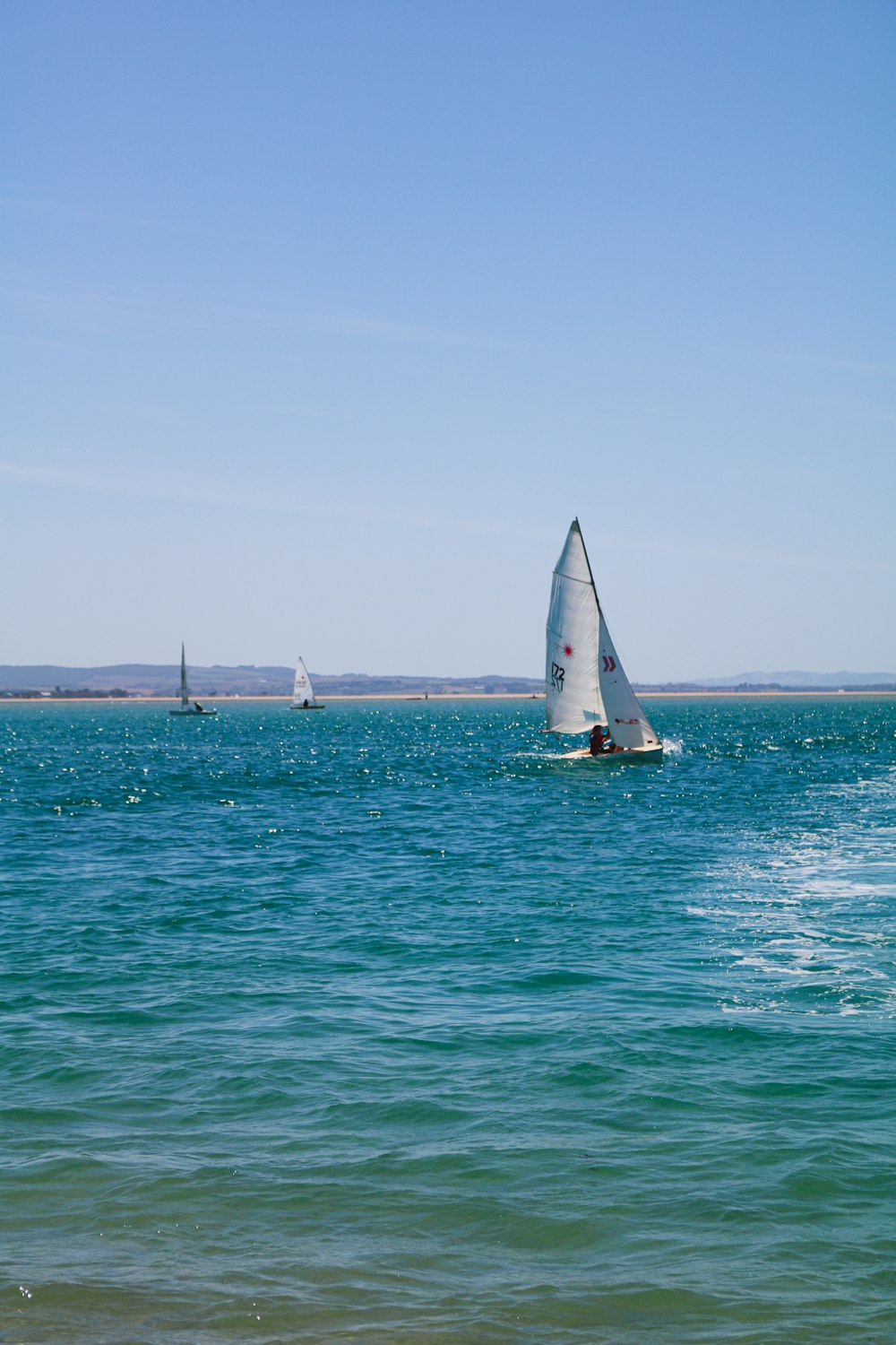 white sail boat on sea during daytime