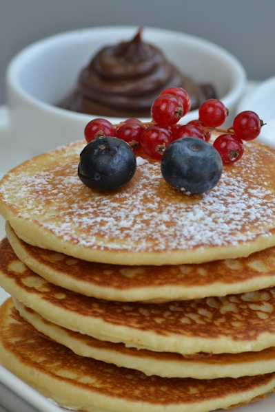 pancakes with berries and berries on white ceramic plate