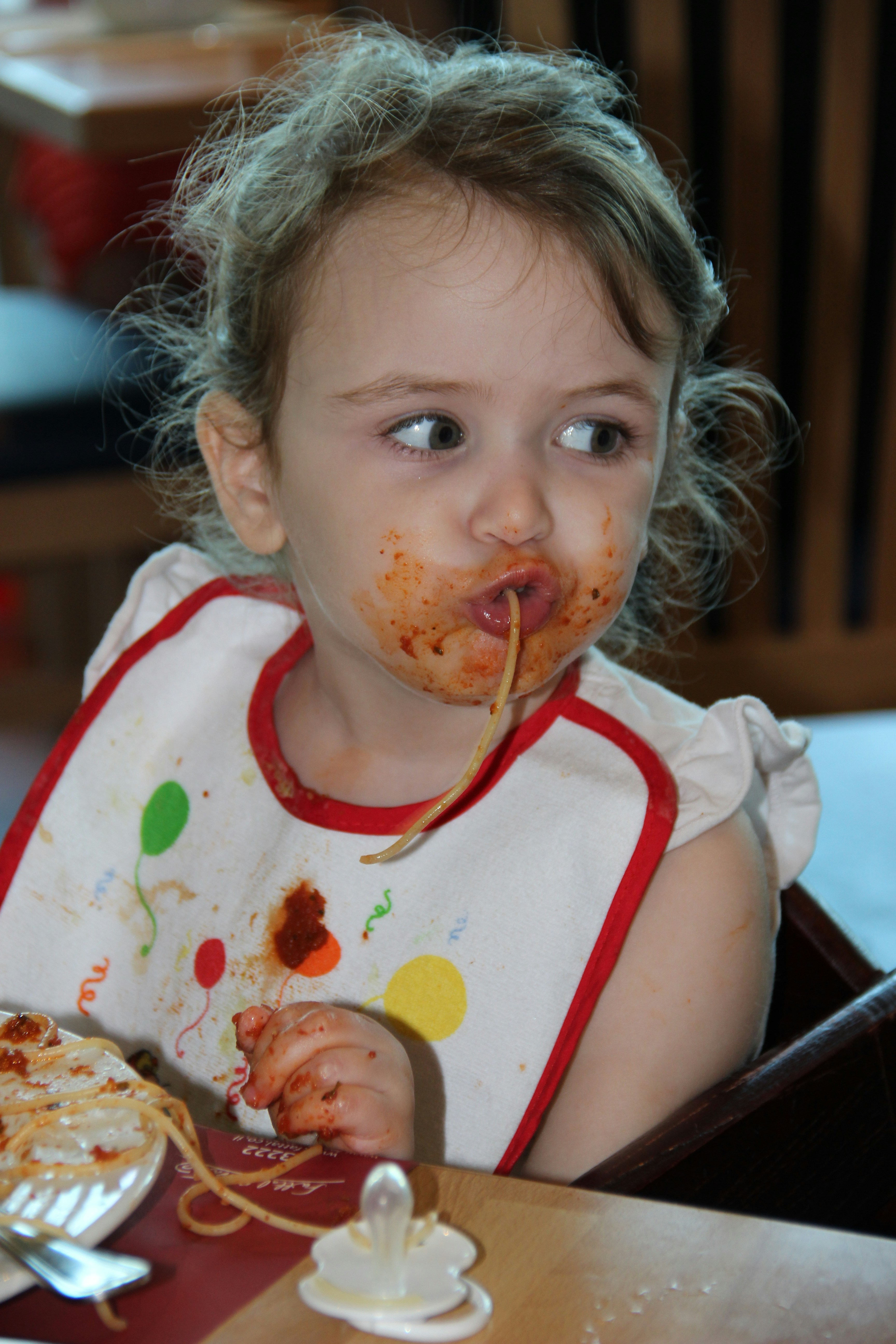 girl in white and red tank top eating pizza