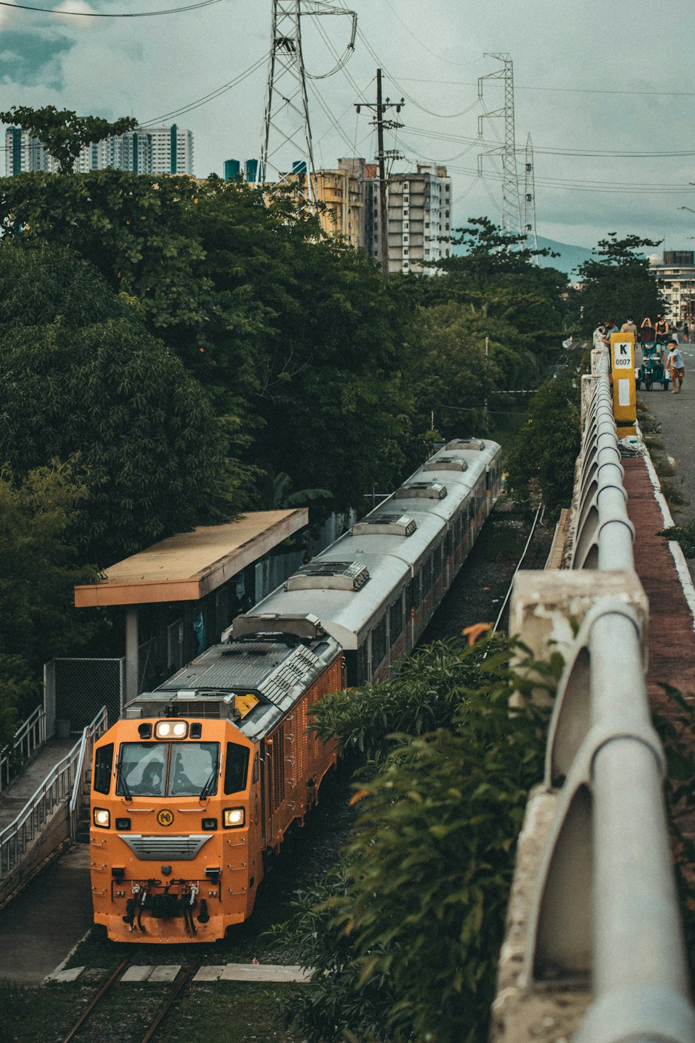 orange and black train on rail road during daytime