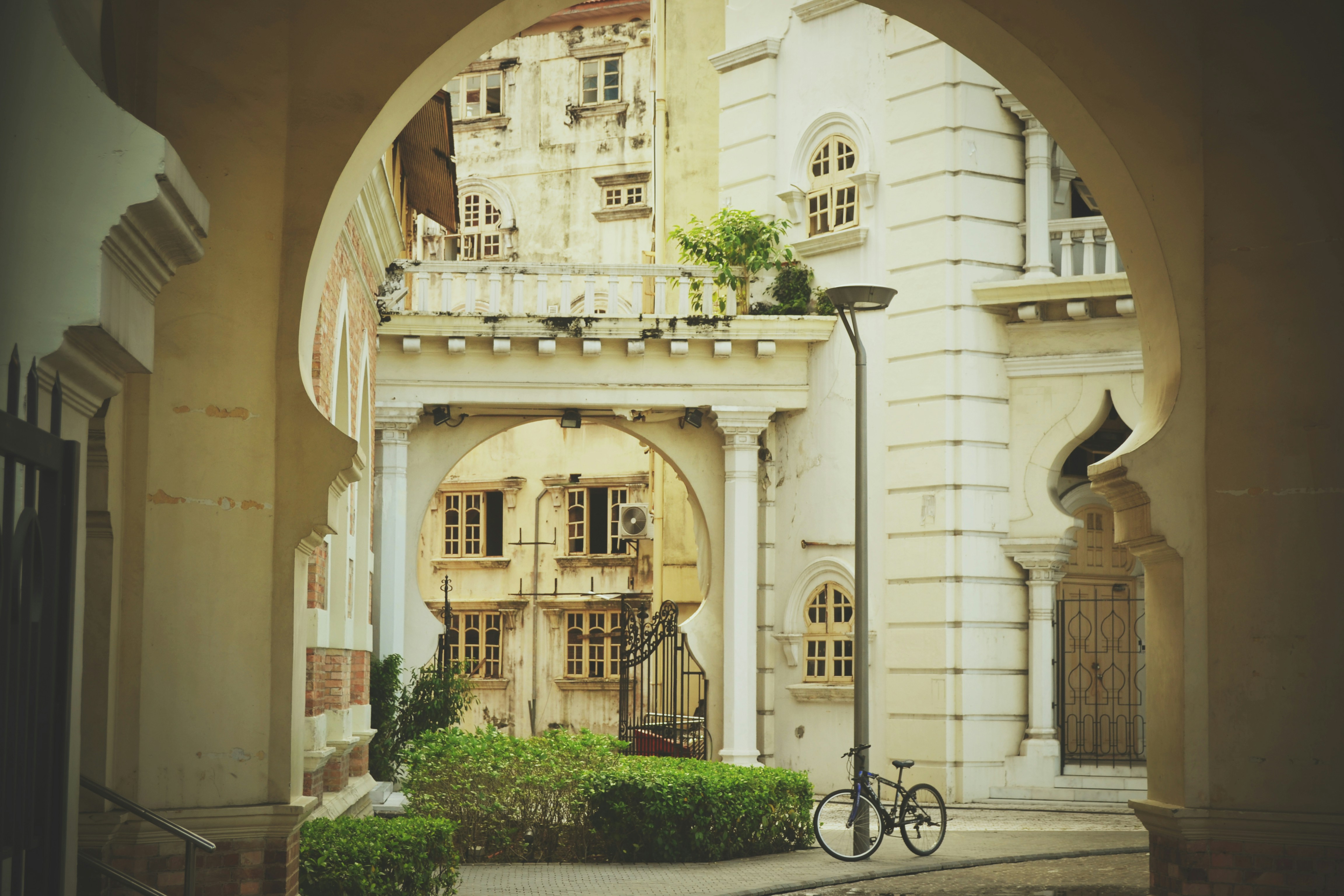 black bicycle parked beside white concrete building during daytime