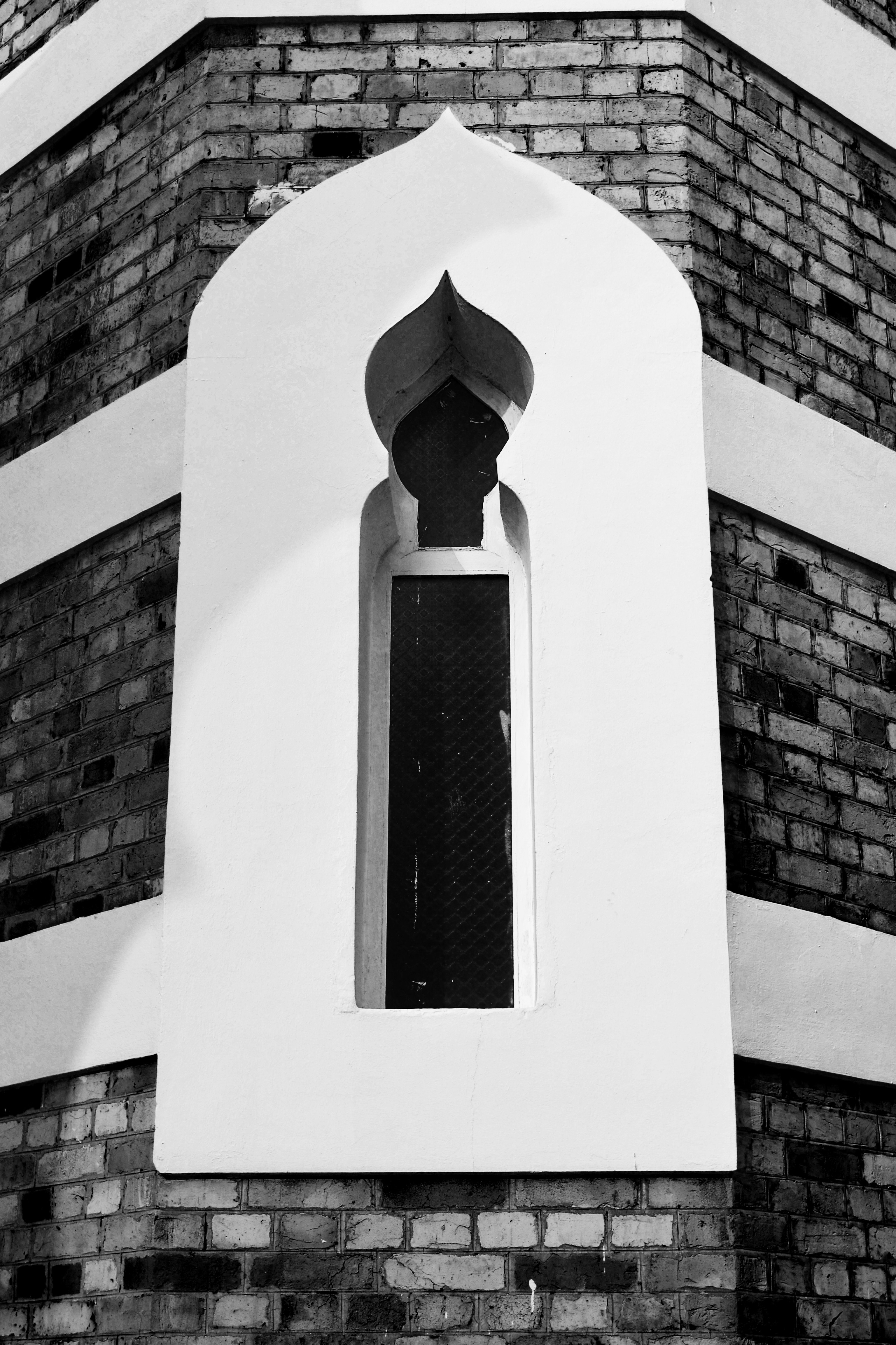 white concrete cross on white concrete wall