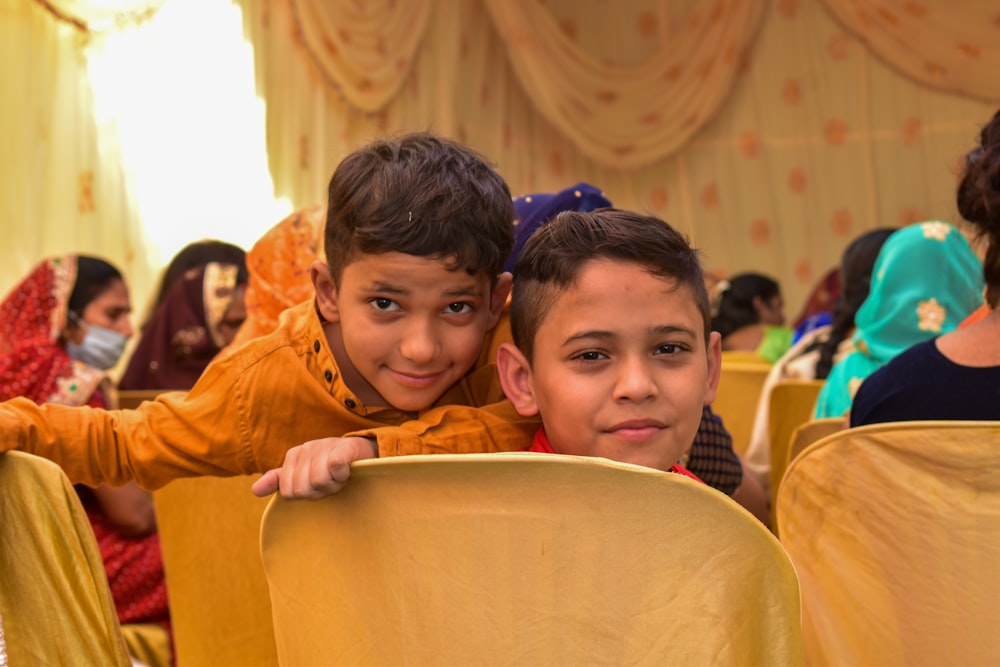 boy in brown jacket beside boy in blue shirt