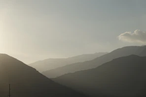 silhouette of mountains under white clouds during daytime
