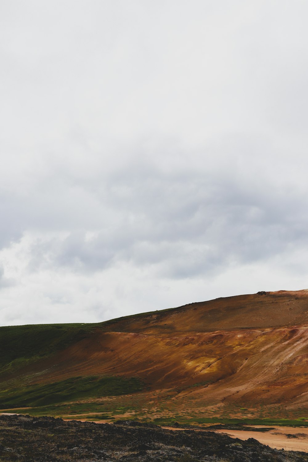 brown and green mountain under white clouds