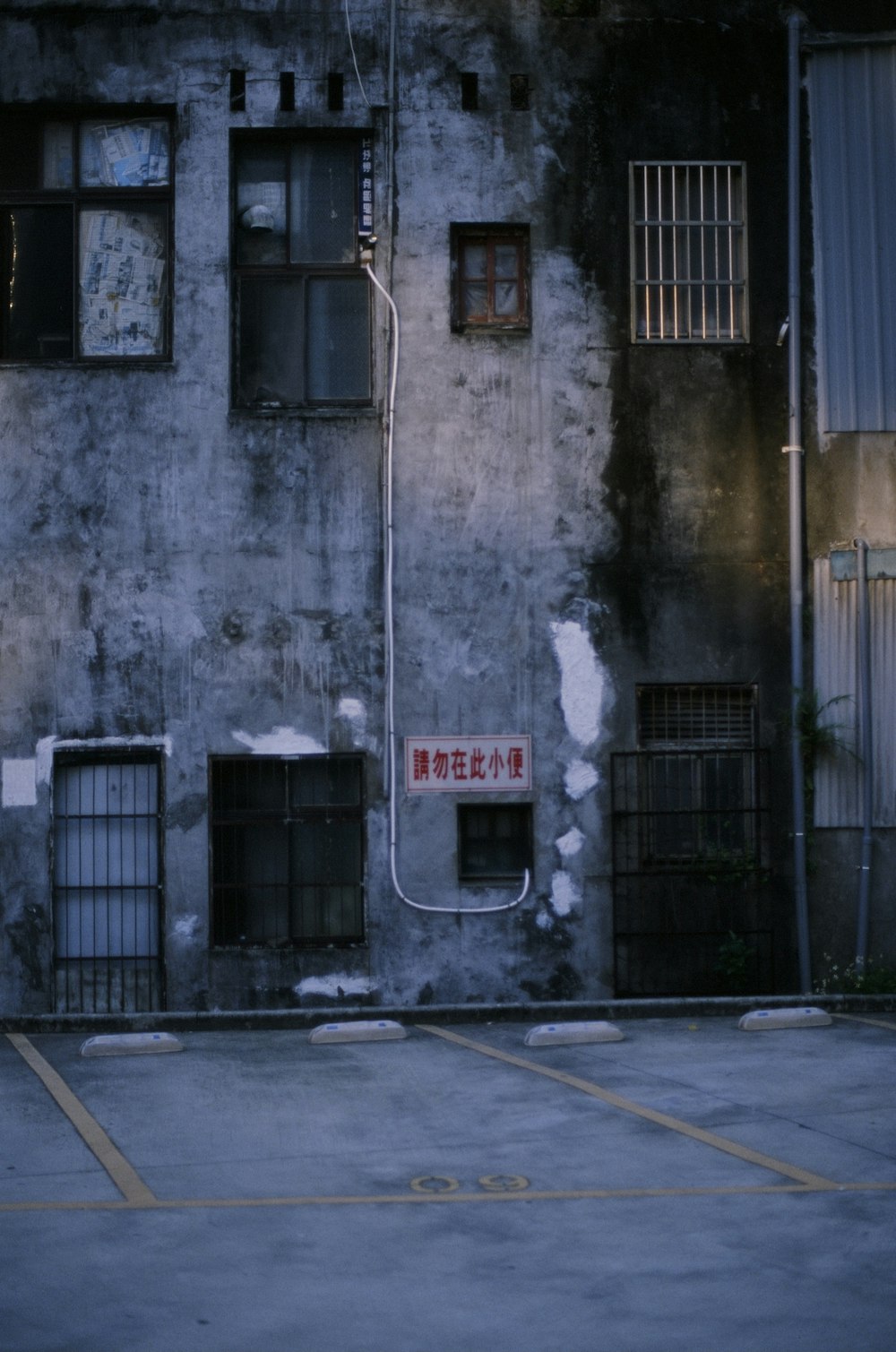 gray concrete building with red and white sign