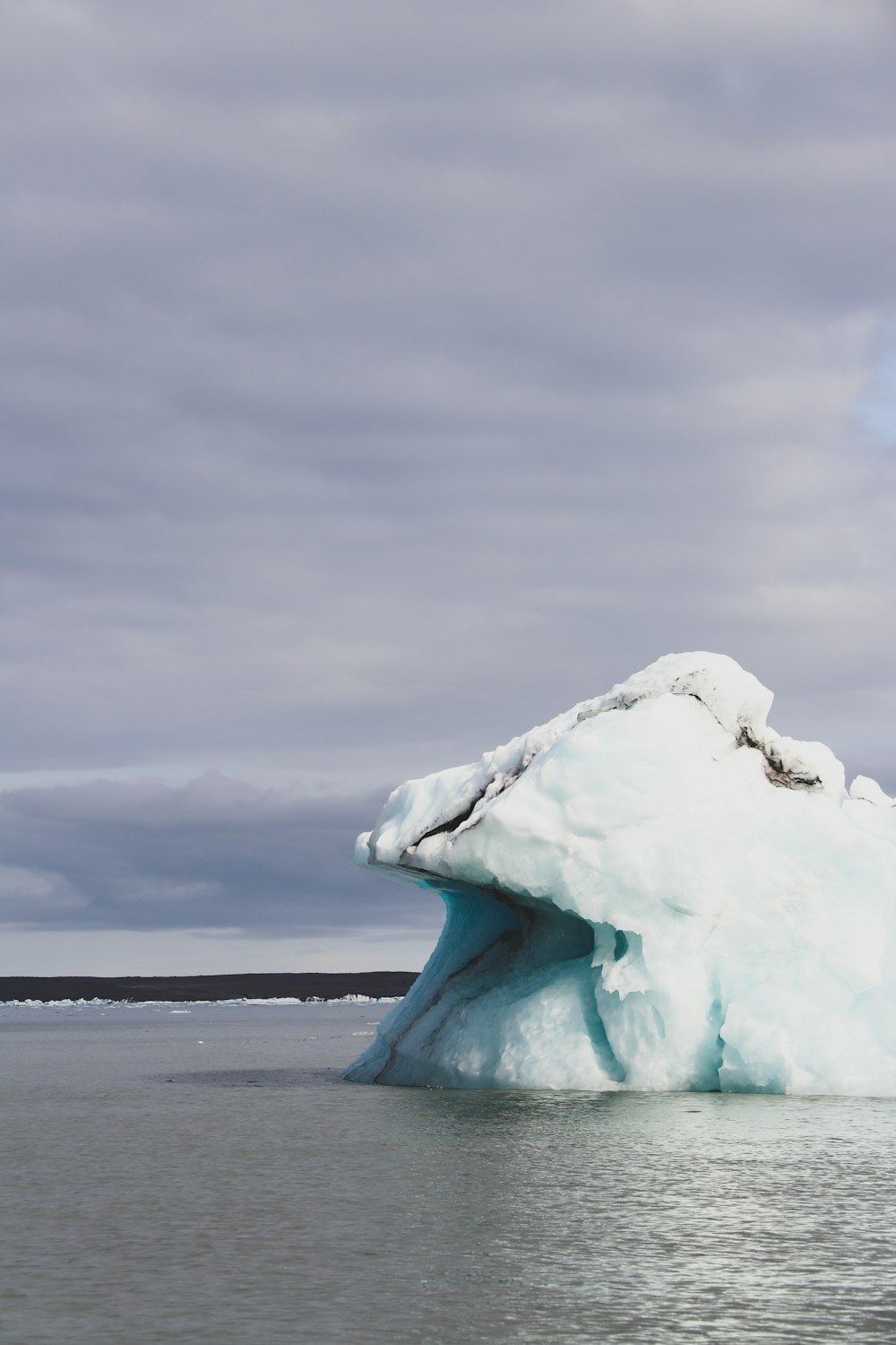 ice formation on sea shore under white clouds during daytime