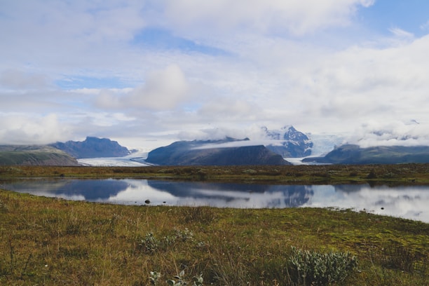 A serene landscape of Glacier Park with lush greenery and mountains in the background.