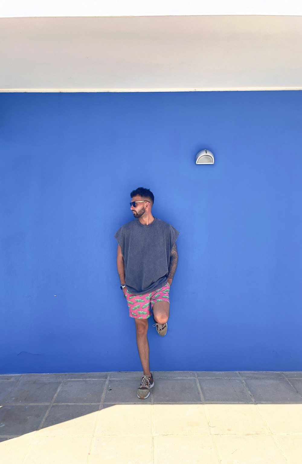 a man standing in front of a blue wall