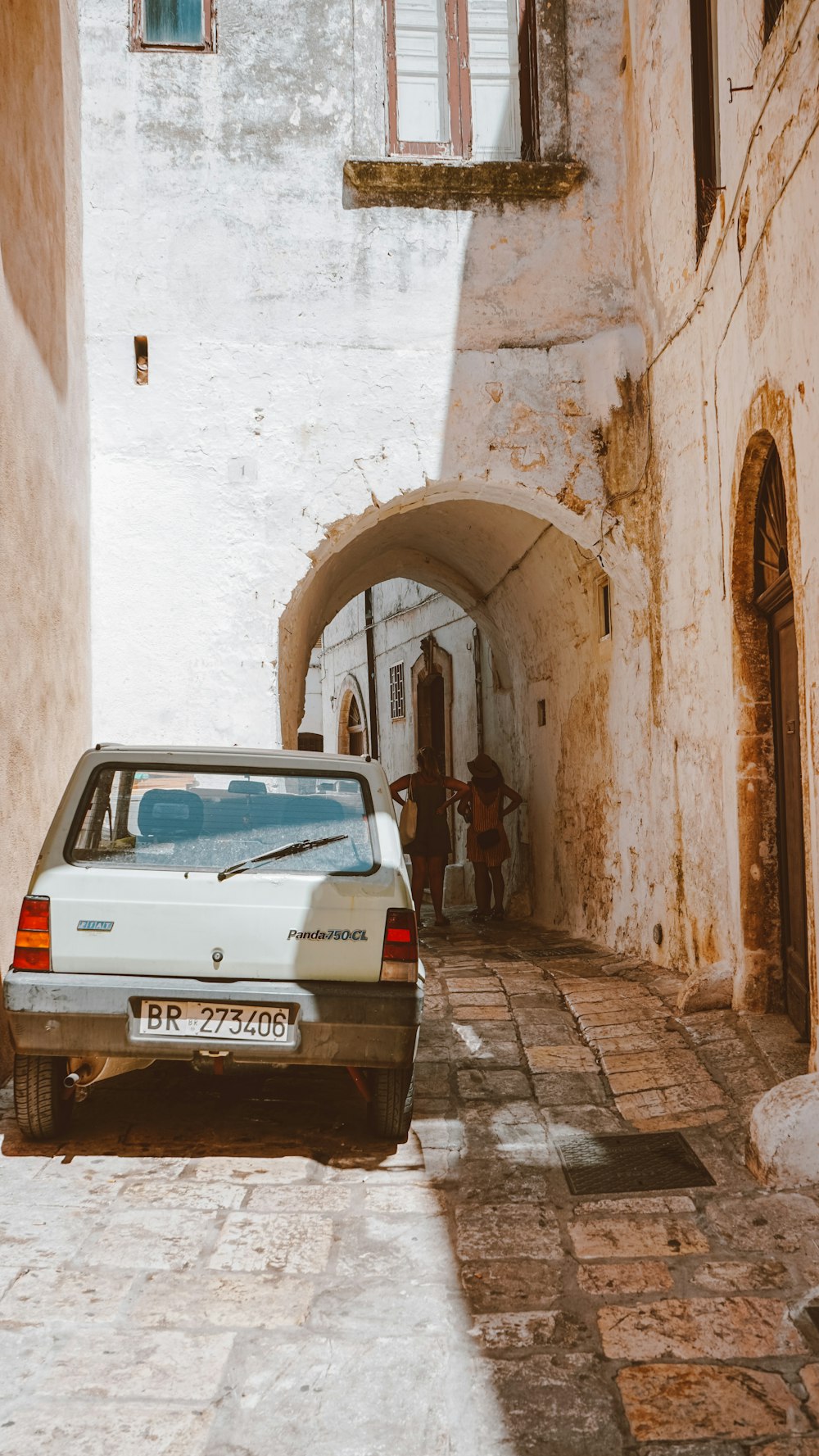 white car parked in front of brown concrete building