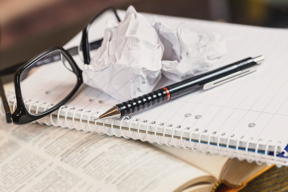 schwarz gerahmte Brille auf weißem Papier