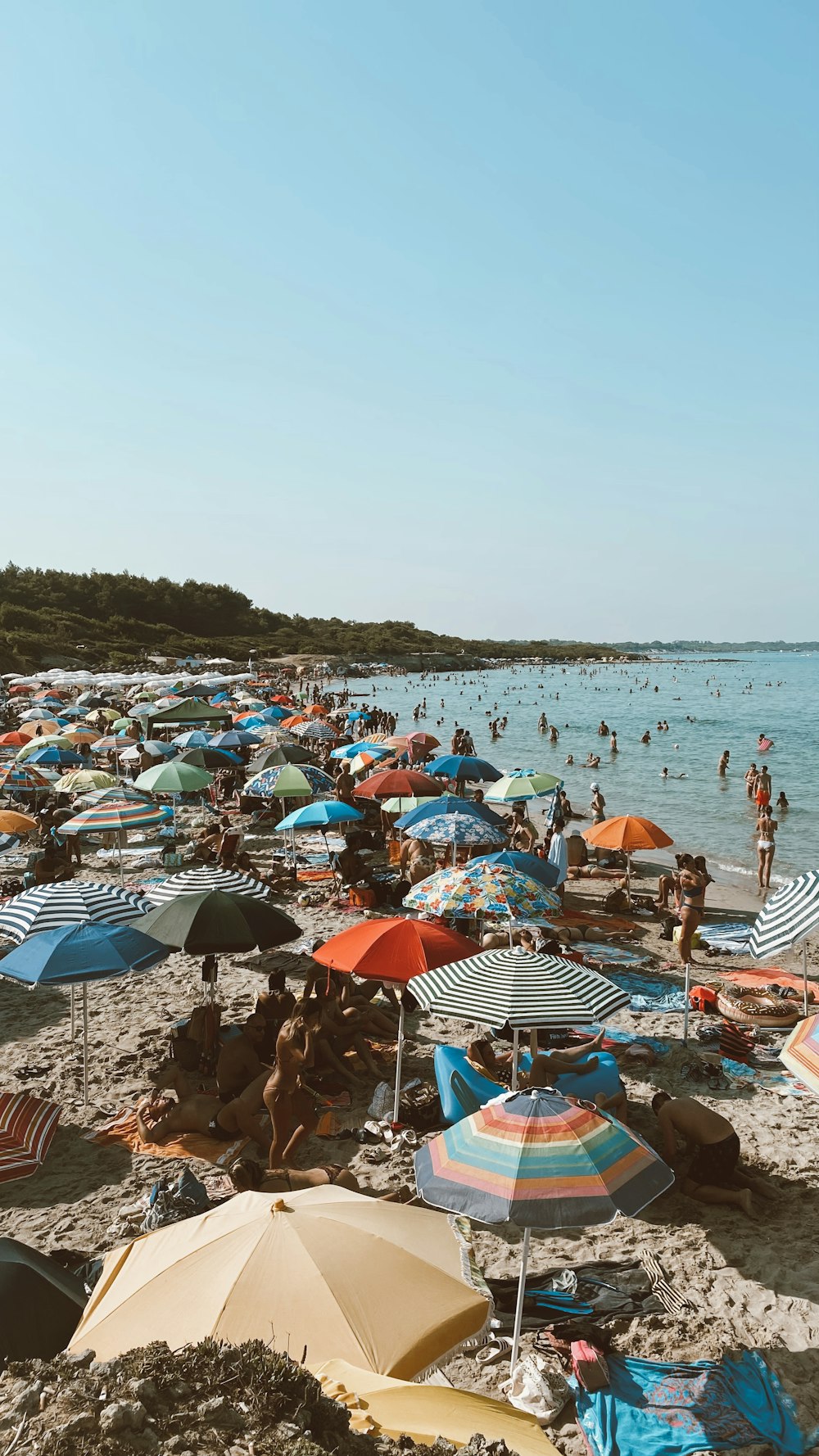 una spiaggia piena di gente e ombrelloni