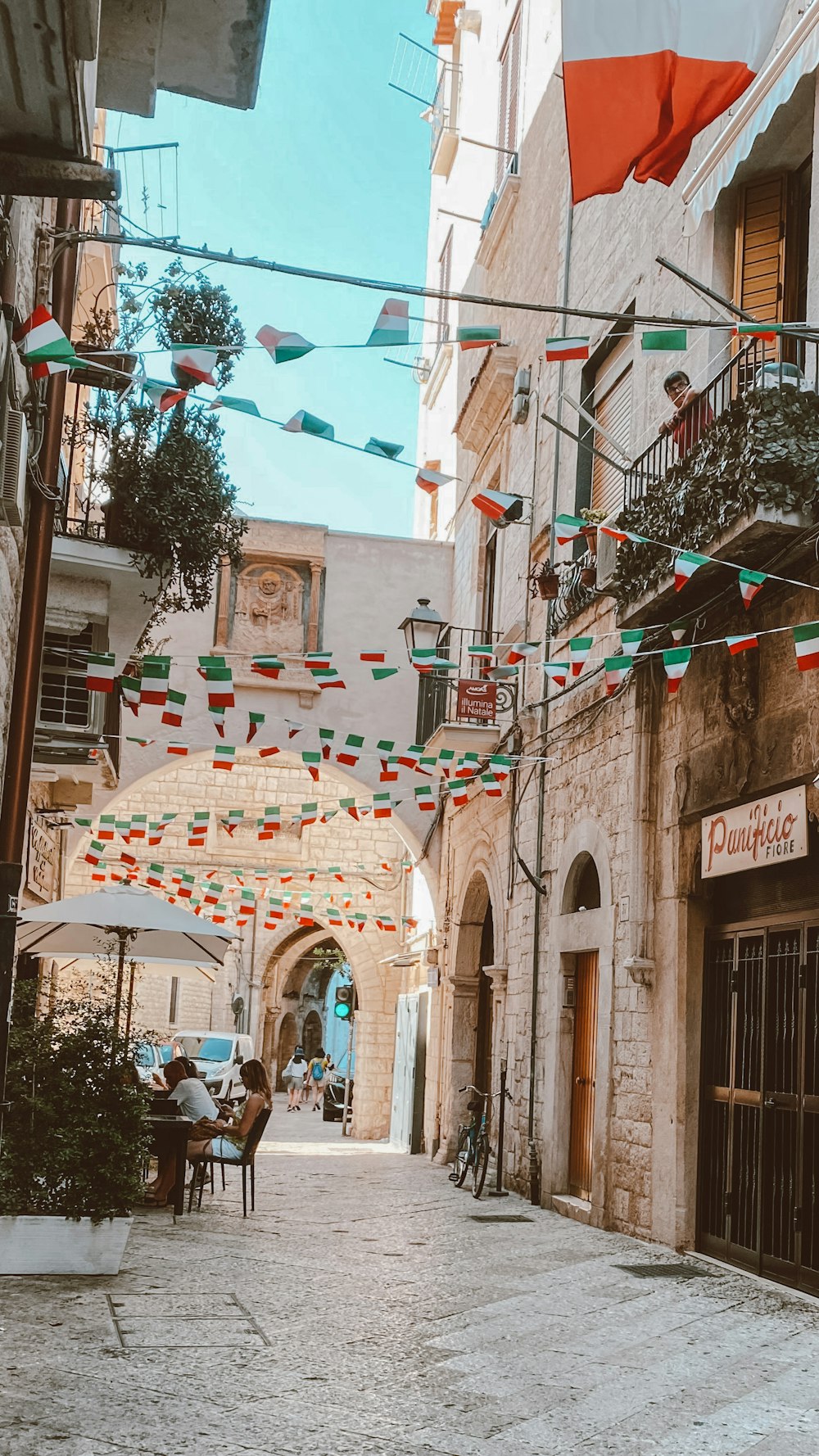 uma rua estreita com bandeiras penduradas nos edifícios