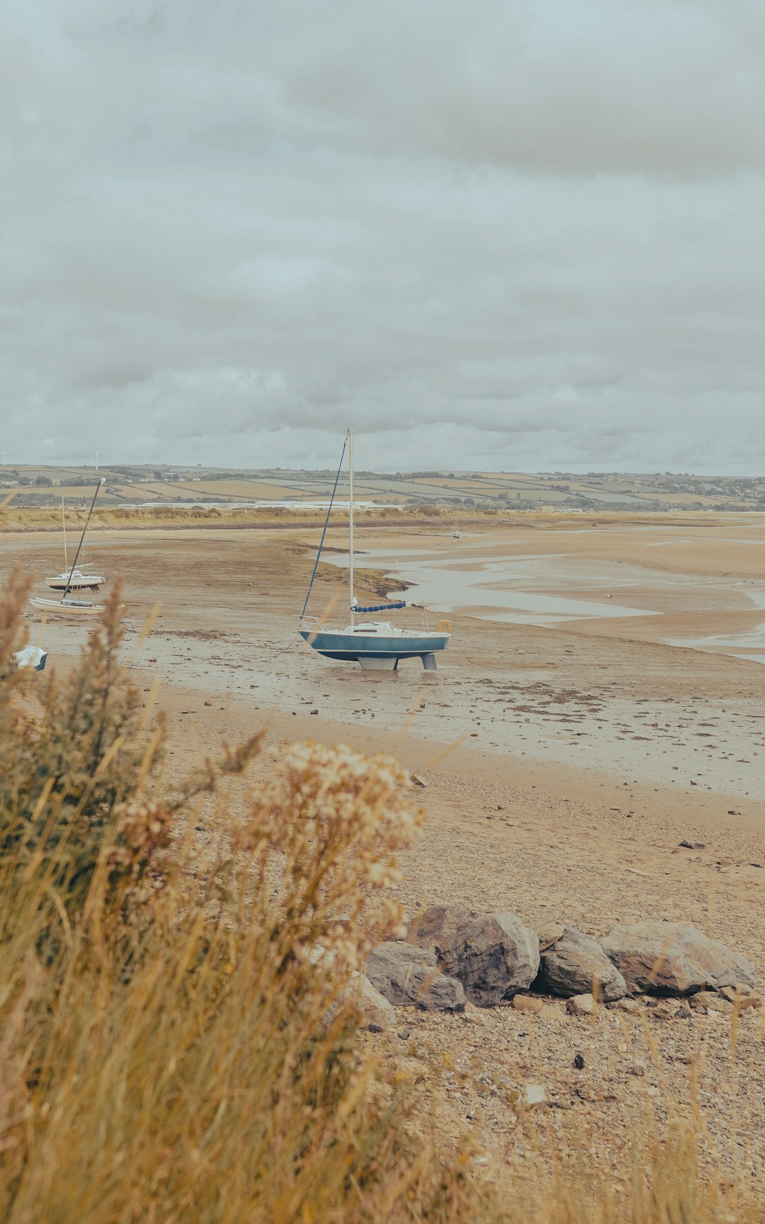 white boat on brown sand under cloudy sky during daytime