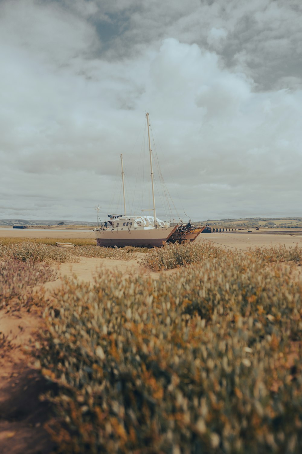 a boat sitting on top of a dry grass field