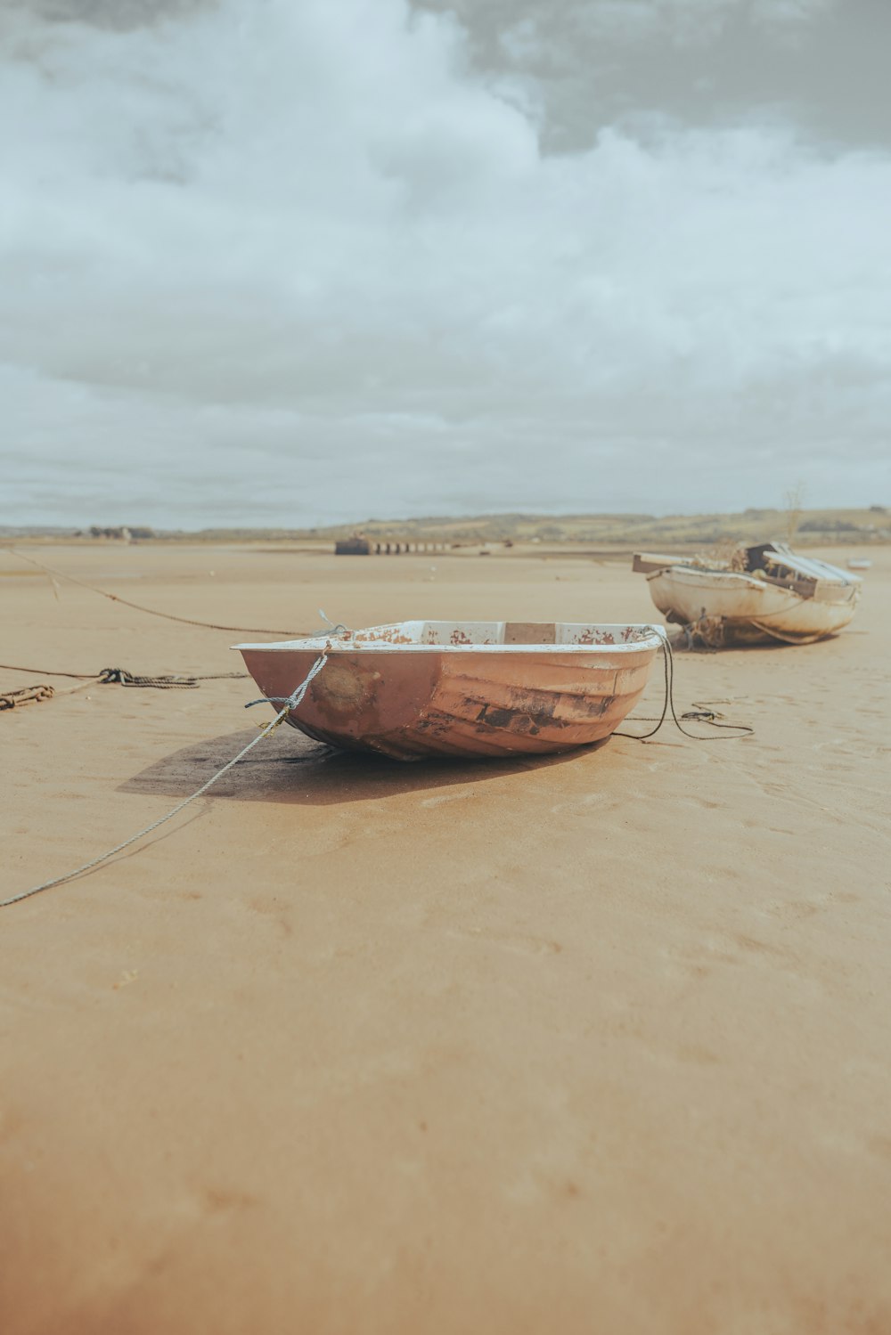 brown and white boat on brown sand during daytime