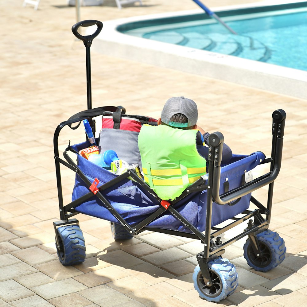 a man sitting in a cart next to a swimming pool