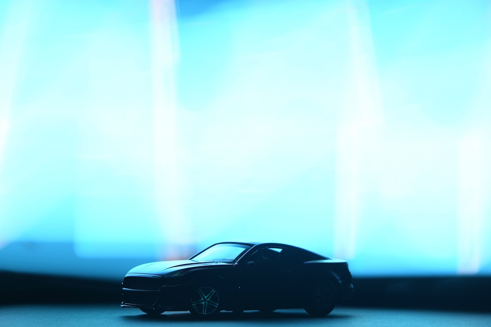 a toy car sitting in front of a blue light