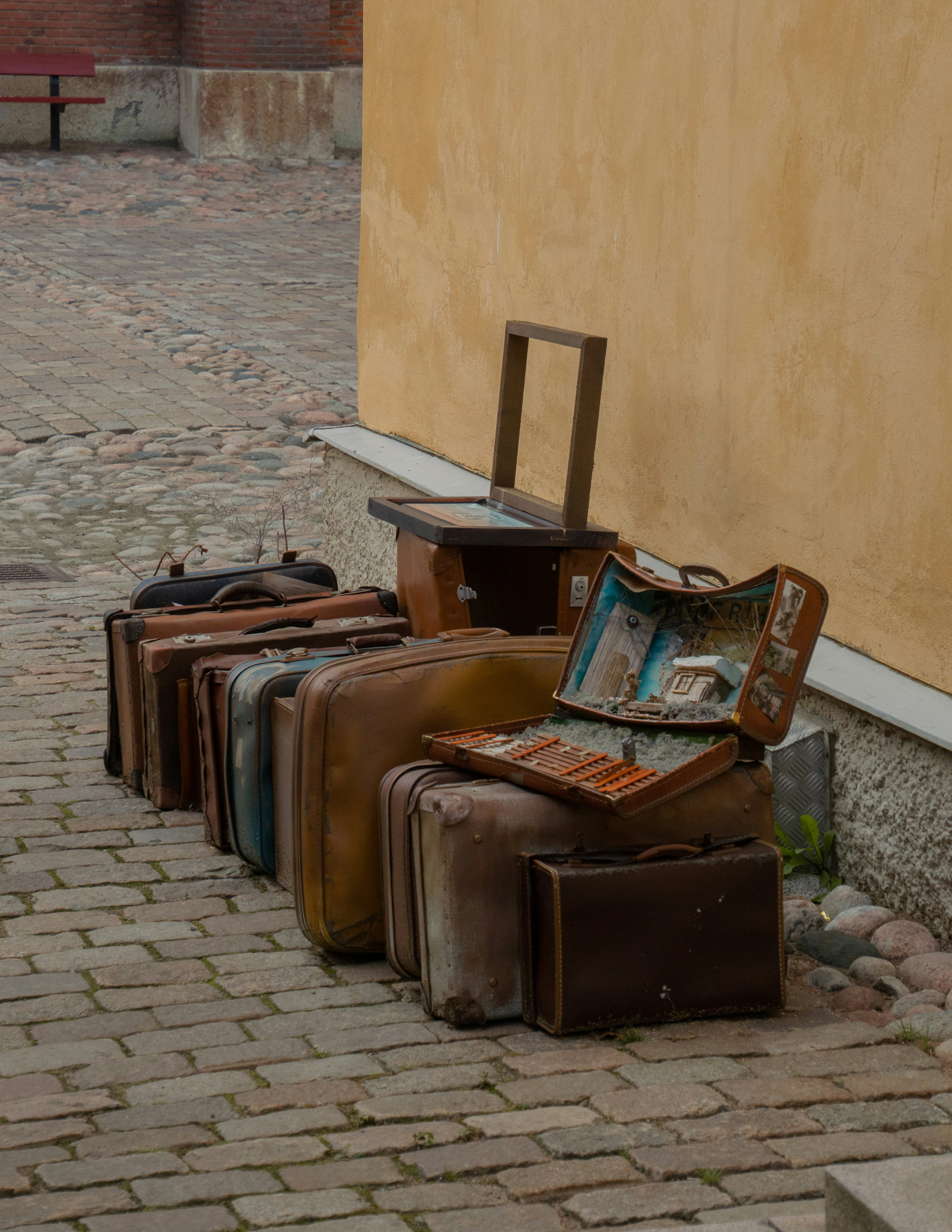 brown wooden bench beside brown concrete wall