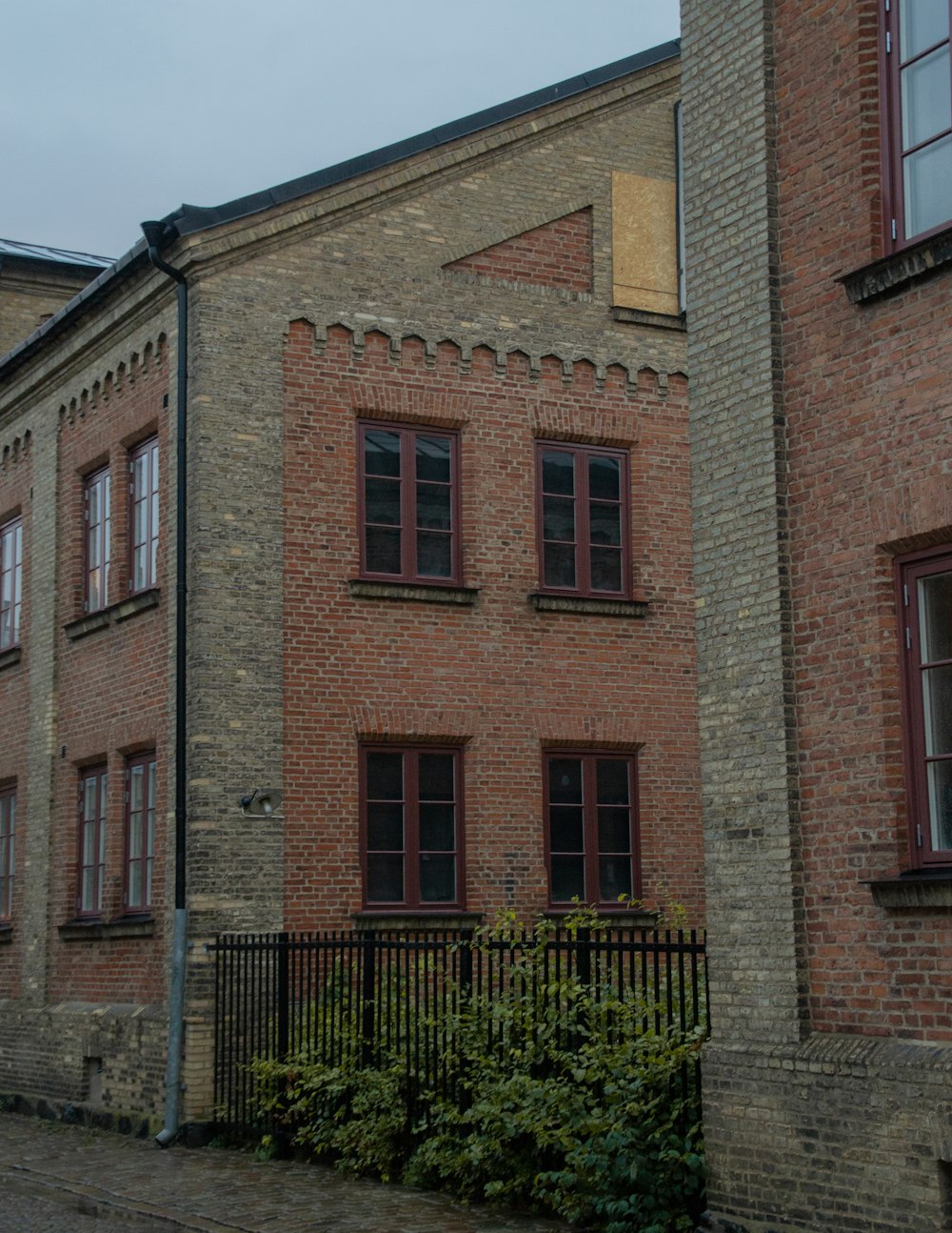 brown brick building with green plants