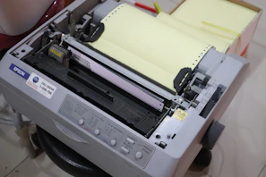 A compact inkjet printer actively printing a colorful document.