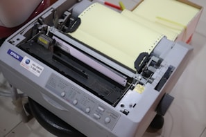 A compact inkjet printer actively printing a colorful document.
