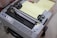 An Epson dot matrix printer with control buttons and a stack of continuous form paper loaded. The printer appears to be in an office or workspace setting.