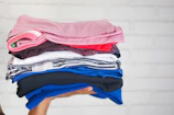 A neatly folded stack of colorful modern clothing in a bright setting