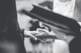 grayscale photo of person holding hands