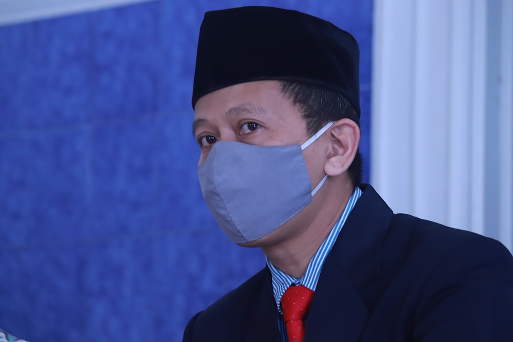 man in black suit wearing white face mask