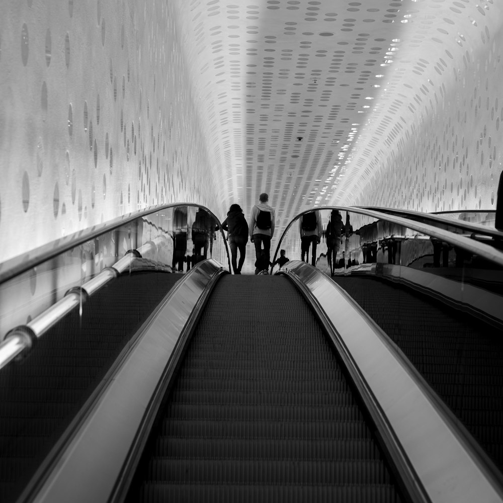 Foto en escala de grises de personas caminando por el túnel