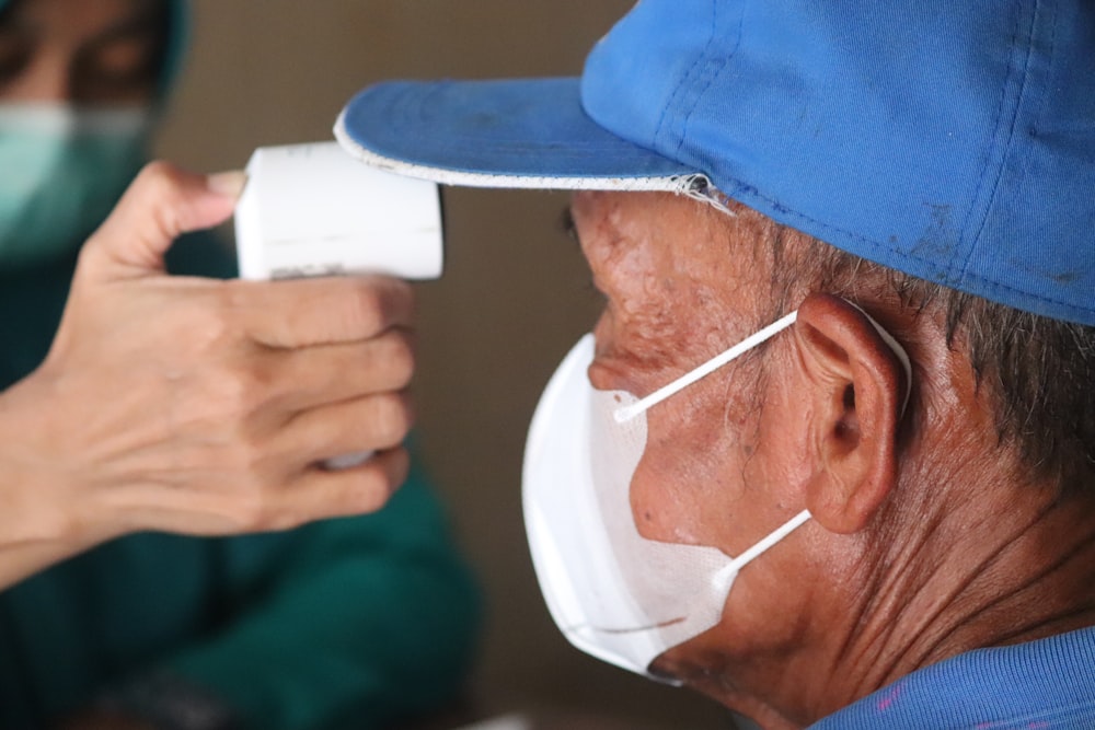 Hombre con camisa azul bebiendo de una taza blanca