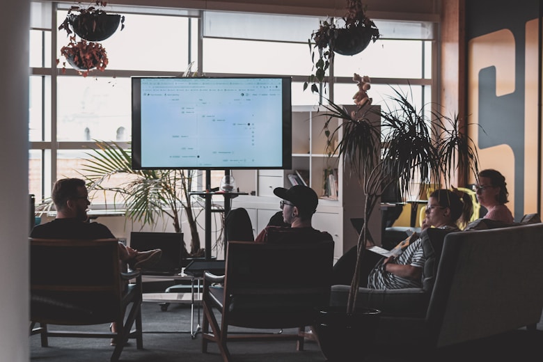 man in black shirt sitting on chair in front of computer monitor