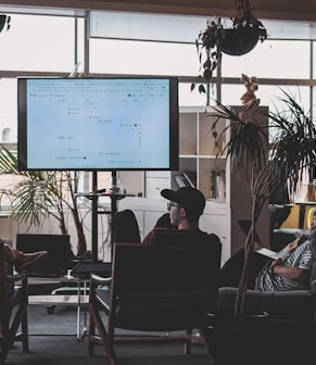 man in black shirt sitting on chair in front of computer monitor