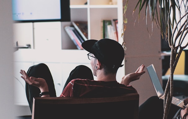 man in black shirt and black hat sitting on black chair