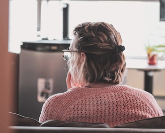 woman in red knit sweater wearing black framed eyeglasses