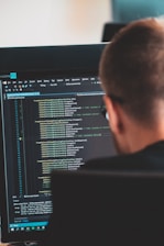 man in black shirt in front of computer monitor
