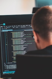 man in black shirt in front of computer monitor