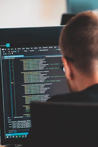 man in black shirt in front of computer monitor