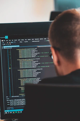 man in black shirt in front of computer monitor