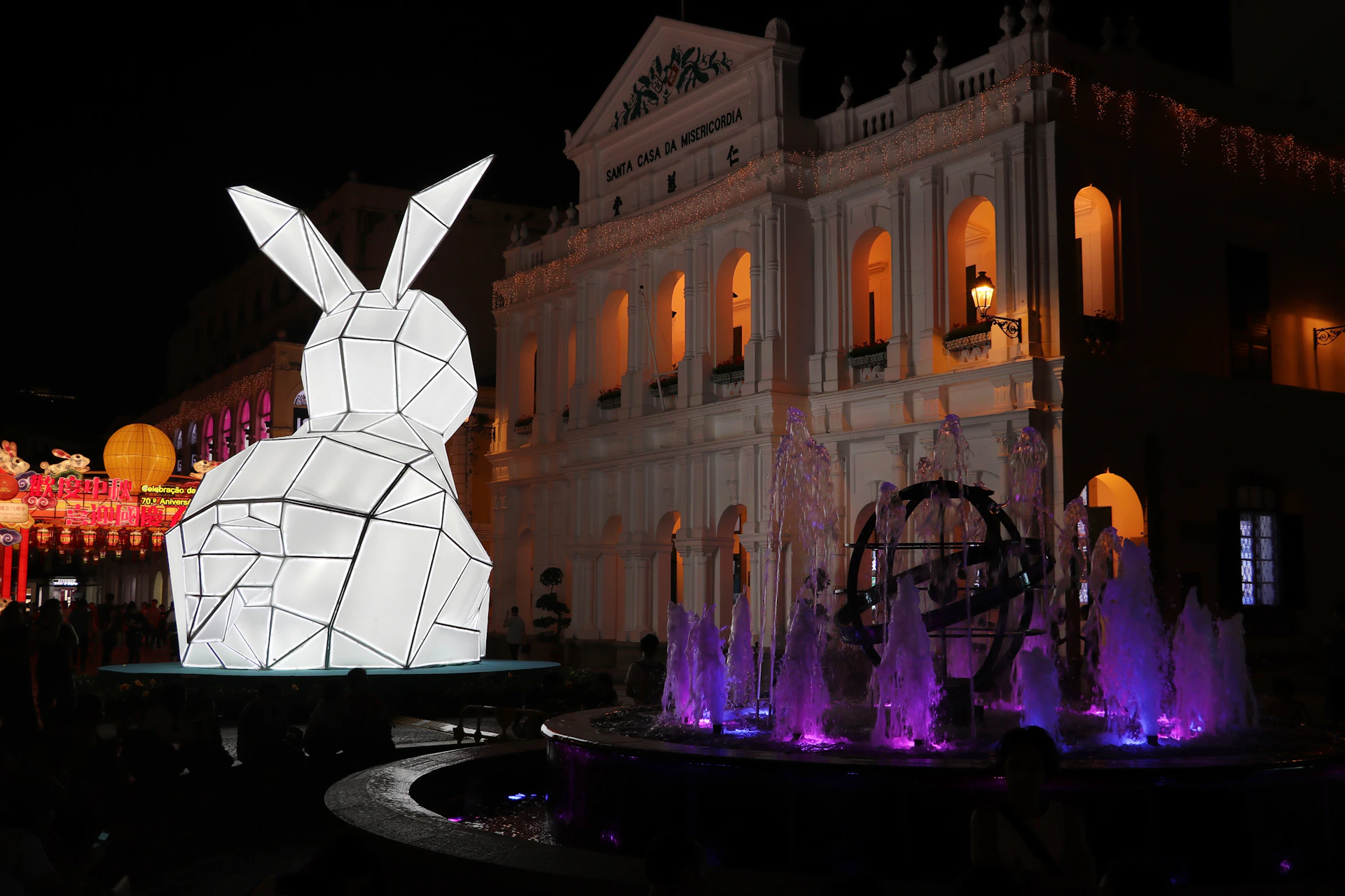 An atmospheric shot of the Królikor installation in an urban setting, showing multiple rabbit figures interacting with the environment.