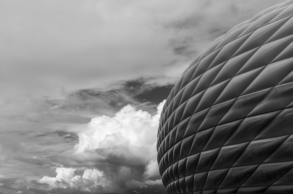 Foto en escala de grises de nubes sobre un edificio