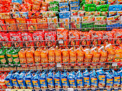 Close-up of vibrant rice and noodle packages neatly arranged on store shelves with clear labels.