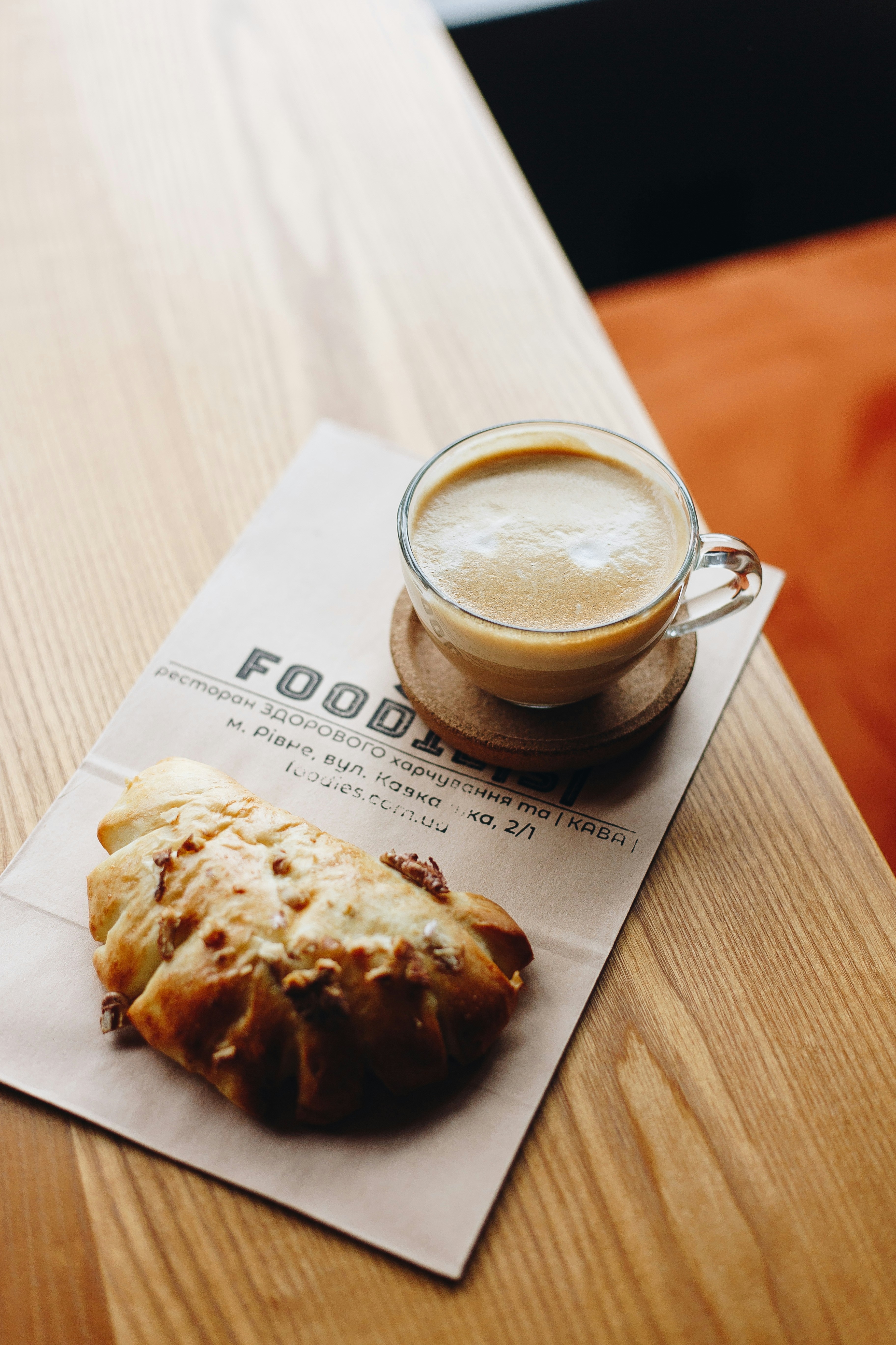 A cup of coffee and a pastry on a wooden table.