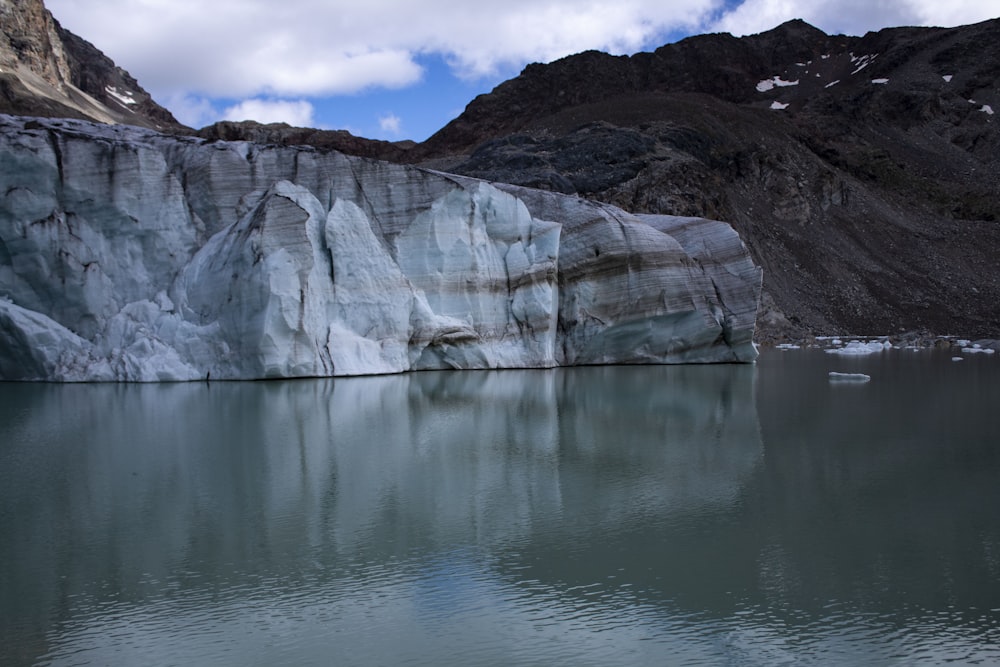 weißer und brauner Berg in der Nähe von Gewässern tagsüber