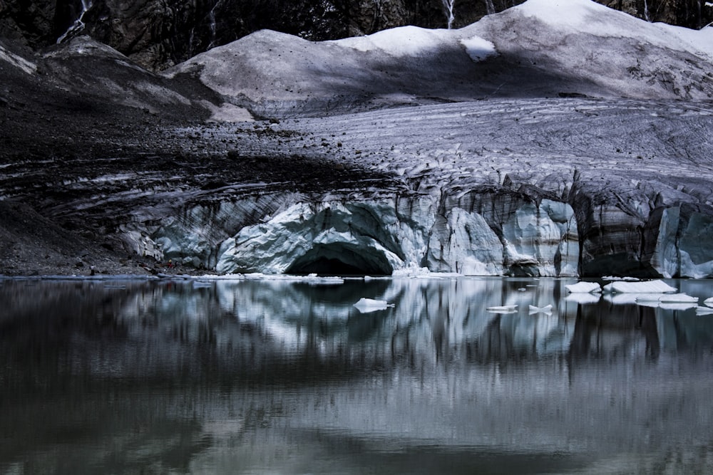 snow covered mountain near body of water during daytime