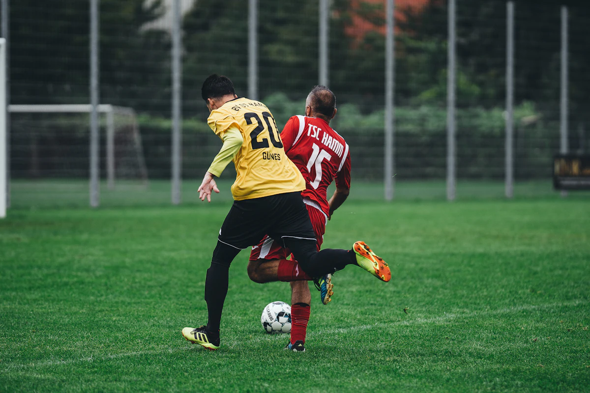Two adult players compete for the ball in an amateur match